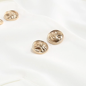 Detail of embossed gold metal button on elegant white fabric of the women business suit
