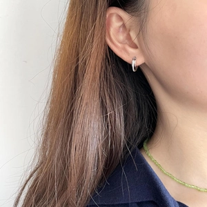 Minimalist 925 sterling silver hoop earrings with cubic zirconia worn by a model