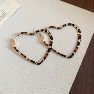 Stylish gold heart-shaped leopard print hoop earrings for women on a textured background