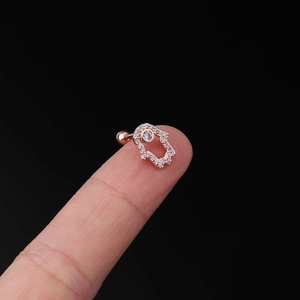 Detailed close-up of a Hamsa Hand tragus earring in rose gold with shimmering zircons