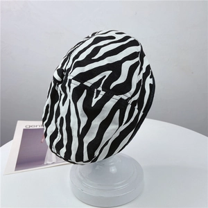 Dettaglio di un berretto con stampa zebrata bianca e nera su una testa di manichino