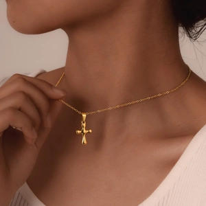 Elegant gold cross necklace for women featuring a minimalist organic design on model