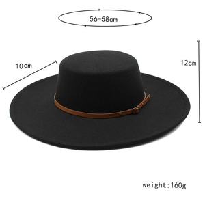 Detail of black wool fedora with brown leather strap and metal buckle accents