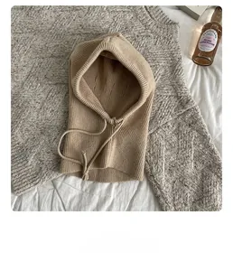 Close-up of beige ribbed knit balaclava hood scarf with drawstring detail on sweater