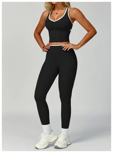 Dettaglio del set da yoga nero con bordo a contrasto bianco e leggings sportivi a vita alta