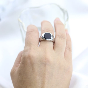 Detailed view of silver stainless steel ring featuring a black square gemstone on finger