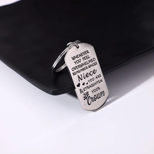 Close-up of engraved stainless steel dog tag keychain with inspirational quote and heart
