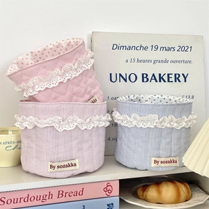 Close-up of quilted fabric baskets with lace trim and soft pastel patterns