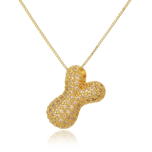 Detailed close-up of a gold-toned peanut pendant necklace with sparkling cubic zirconia