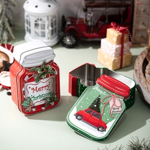 Close-up of festive Merry Christmas tin jars with gingerbread and car patterns on table