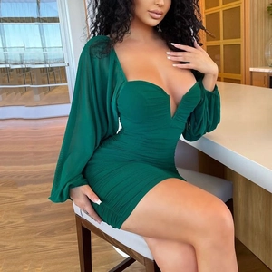 Detail of green V-neck mini dress with lantern sleeves and ruched texture on a model