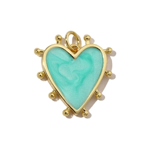 Detail of a mint green heart pendant with gold-plated edging and cubic zirconia accents