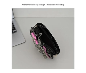 Close-up of gothic punk shoulder bag featuring metal spikes, chains, and open interior pocket