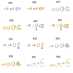 Set of gold and silver plated earrings with moon, star, and snake charms on a white background