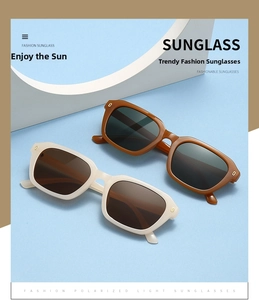Detail of amber and cream square sunglasses with decorative rivets on blue background