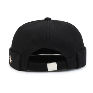 Black cotton Miki hat with golden bird pin and adjustable silver metal buckle on back