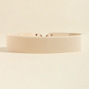 Close-up of elastic wide waist belt with vintage buckle and beige faux leather details