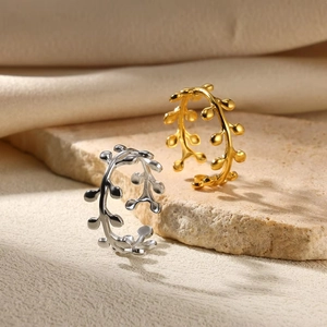 Detailed view of gold and silver textured twig rings on a stone slate background