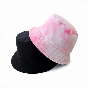 Detail of reversible cotton bucket hats in solid black and pink tie-dye patterns