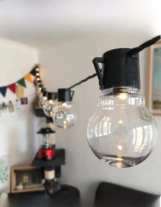 Detail view of G50 LED solar string lights with clear bulbs and warm yellow glow