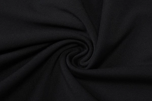 Detailed macro view of black ribbed knit fabric showing soft spiral draped texture