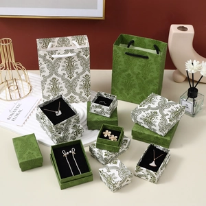 Detail of luxury emerald green jewelry boxes with white baroque patterns and gold accents