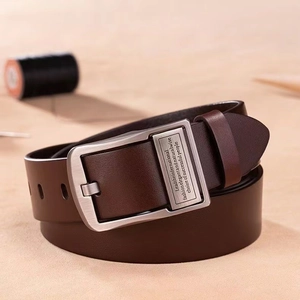 Détail de ceinture en cuir marron vintage pour homme avec boucle en bronze gravée