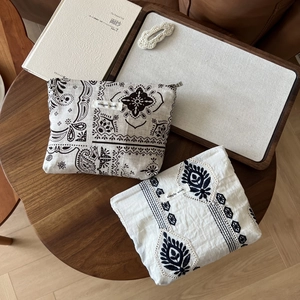 Macro view of vintage linen pouches with intricate ethnic patterns on a wooden table