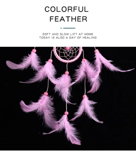 Detail view of soft pink feathers and decorative beads on the dream catcher