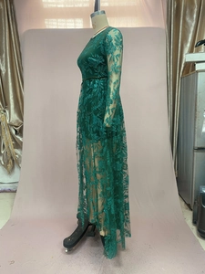 Detail of green long-sleeved evening gown featuring intricate sequin floral embroidery