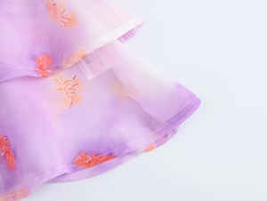 Detail of floral chiffon fabric with ruffled hem and 100% polyester care label tag