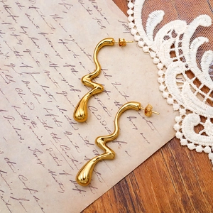 Vue macro des boucles d'oreilles dorées sur papier vintage avec dentelle élégante