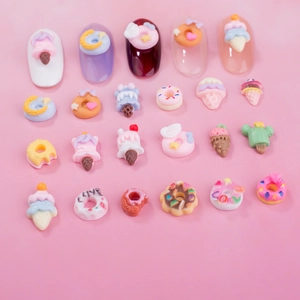 Macro detail of 3D resin nail art charms in colorful donut and ice cream shapes