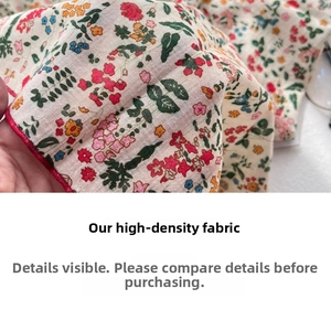 Close-up of high-density cotton linen fabric with colorful floral print and red stitched edges