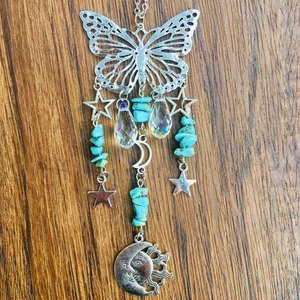 Detail of silver suncatcher featuring butterfly, moon, turquoise and faceted crystal