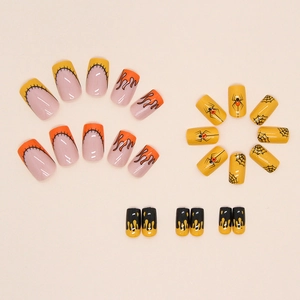 Macro shot of Halloween false nails with orange flame, black spider web and gem accents