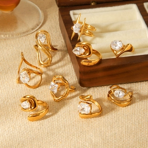 Gold plated stainless steel rings set with zircon stones on a beige jewelry display