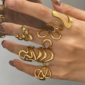 Irregular liquid metal style gold rings shown on hands with abstract wavy line details