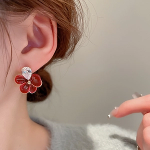 Boucles d'oreilles fleurs rouges rétro avec zircon goutte portées par un mannequin