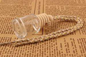 Close-up of clear 8ml glass car perfume bottle with wooden lid on vintage newspaper