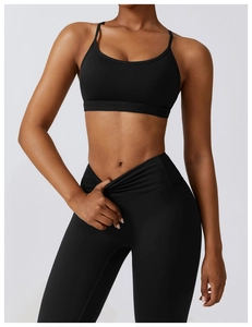 Détail du legging de yoga noir à taille croisée et de la brassière à fines bretelles