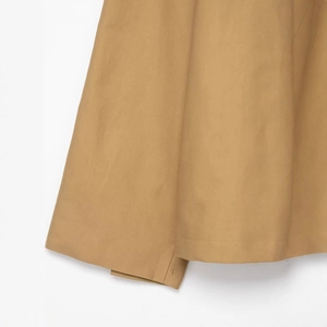 Detailed close-up of khaki short trench coat featuring premium stitching and woven texture