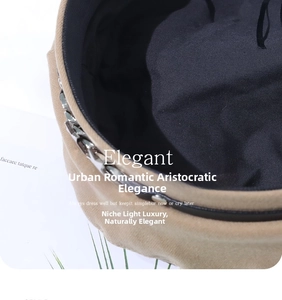 Close-up of camel beret hat featuring a chunky silver metal chain and soft black lining