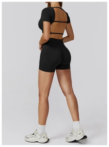 Detail of black seamless yoga set featuring open back cutout top and high waist shorts