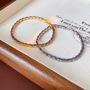 Detail of silver and gold plated bracelets with oval purple zircons in a jewelry tray