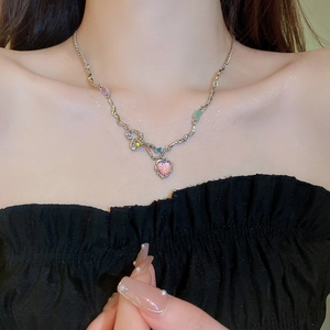 Détail du collier cœur d'opale avec pendentif rose et perles colorées porté par un mannequin
