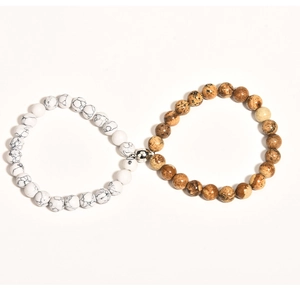 Macro shot of white and brown beaded bracelets connected by a magnetic heart clasp