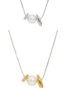 Close-up of gold and silver snake chain necklaces with large pearl pendants