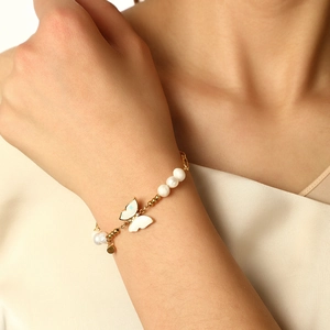 Detail of 14K gold butterfly pendant with pearl accents on a stainless steel chain
