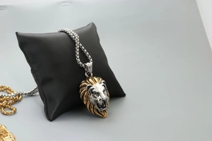 Detail of roaring lion head pendant in two-tone gold and silver on a box chain